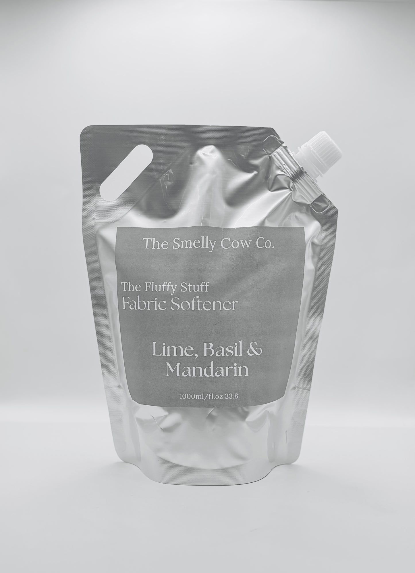 A silver pourable pouch with a minimalist label with lime, basil and mandarin scented fabric conditioner inside.